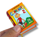 Small book or notebook with a colorful cover featuring a character and text, held by a hand.Condorito