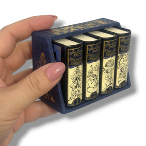 Set of miniature books in a blue case held by a hand. Gulliver's Travels