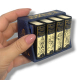 Set of miniature books in a blue case held by a hand. Gulliver's Travels