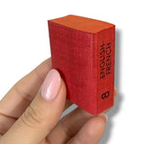 Red book with 'English-French' text held by a hand on a white background. Lilliput Dictionary
