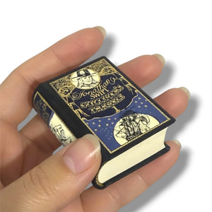 Hand holding a miniature book with decorative cover. Gulliver's Travels