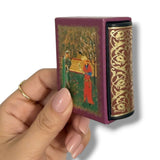 Hand holding a decorative box with intricate designs on a white background Rubaiyyat