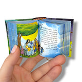 Children's Bible mini book open. Miniature book with colorful illustrations and text held by a hand