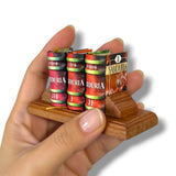 Hand holding a miniature bookshelf with 'Sabiduria' books on a white background