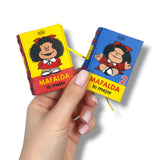 Two small books with Mafalda on the cover held by a hand against a white background