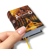 Hand holding a book titled 'El Anticristo' by Nietzsche on a white background