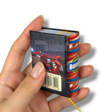 Hand holding a small, detailed model of a baseball book with colorful design
