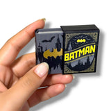 Hand holding a small book with Batman design on the cover