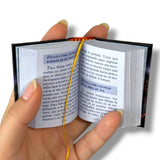 Beisbol. Hand holding a small open book with text on a white background