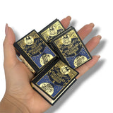 Four small books with decorative covers held in a hand against a white Gulliver's Travelsbackground