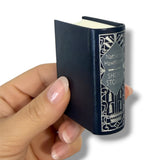 Hand holding a small book titled 'Short Stories' by Nathaniel Hawthorne on a white background