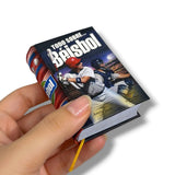 Small book titled 'Todo sobre Básbol' held by a hand on a white background