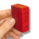 Red brick with 'English Italian' text held by a hand on a white background